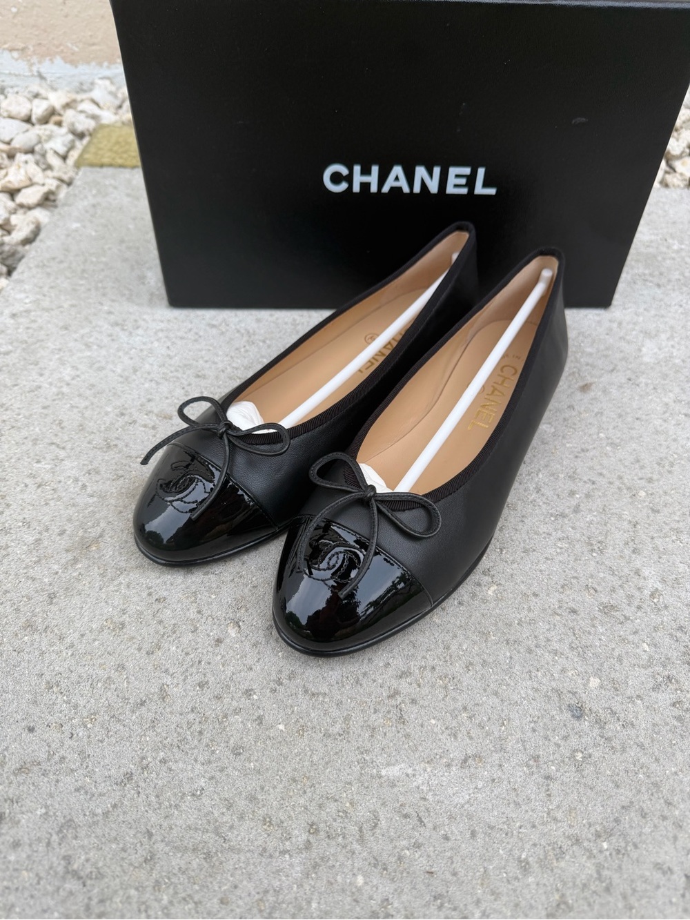 CHANEL Black Leather Ballet Flats with Patent Cap Toe and Bow